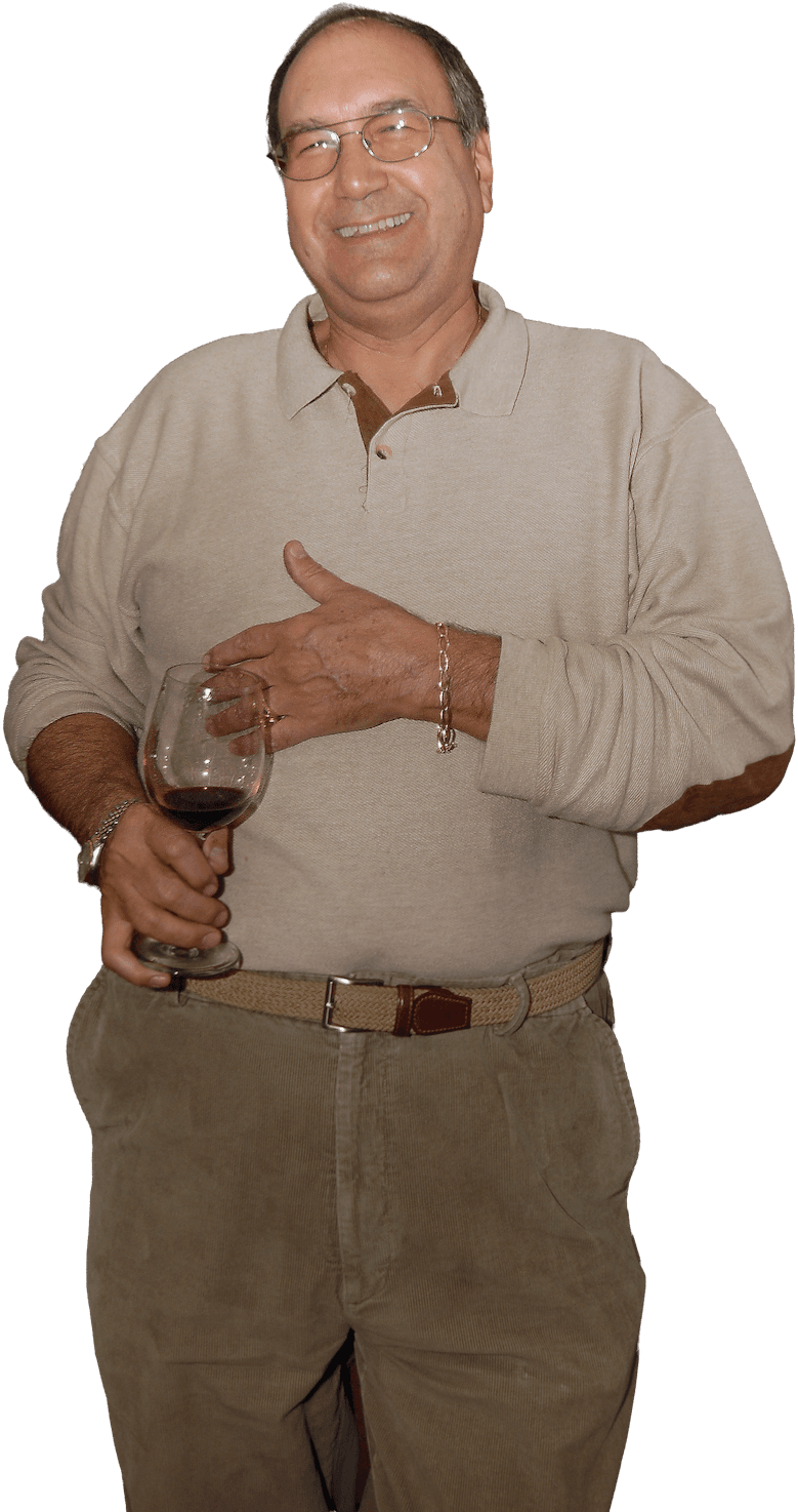 Dr. Juan Palomar smiling warmly, holding a glass of wine